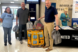 Commission Members with bags of supplies for the UNITED WAY school drive